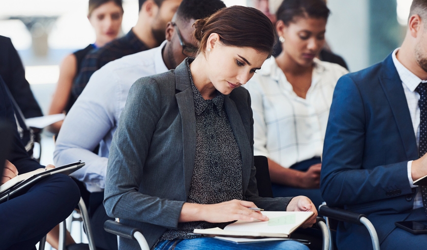 Cropped shot of a businesswoman making notes during a conference