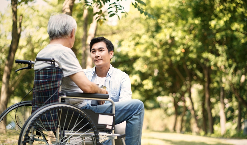Caregiver helping elderly person in a wheelchair