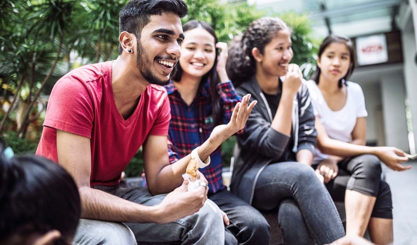 Multi Ethnic Group Of Students Joking And Getting To Know Each Other Better On Lunch Break in University Yard