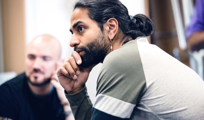 Close up shot of a mid-adult man listening to someone speaking whilst sitting