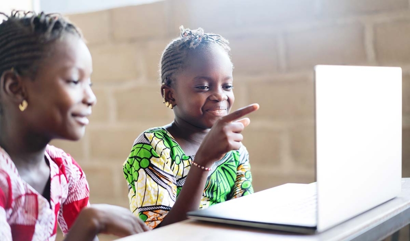 Two Funny Girls Smiling and Laughing at Computer Laptop Screen