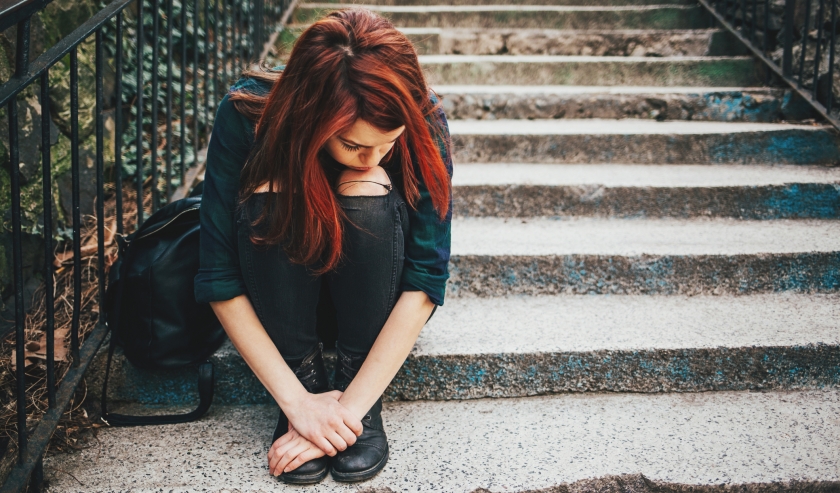 Sad lonely girl sitting on stairs