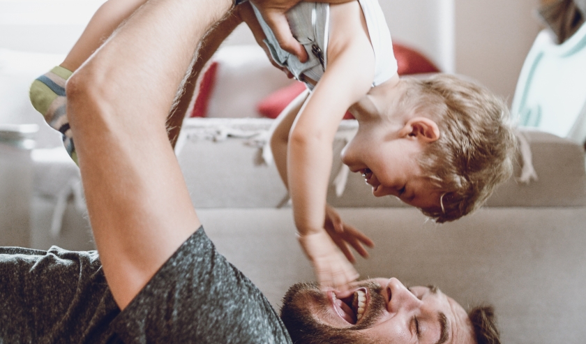 Parent lifting child up playfully