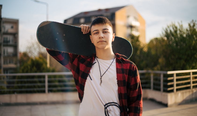 Young man carrying a skateboard