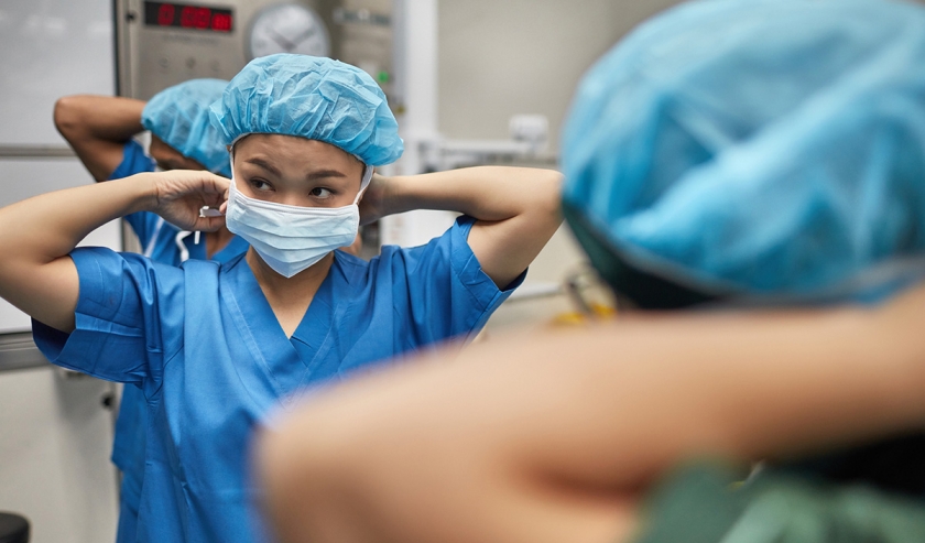Medical professional putting on surgical scrubs