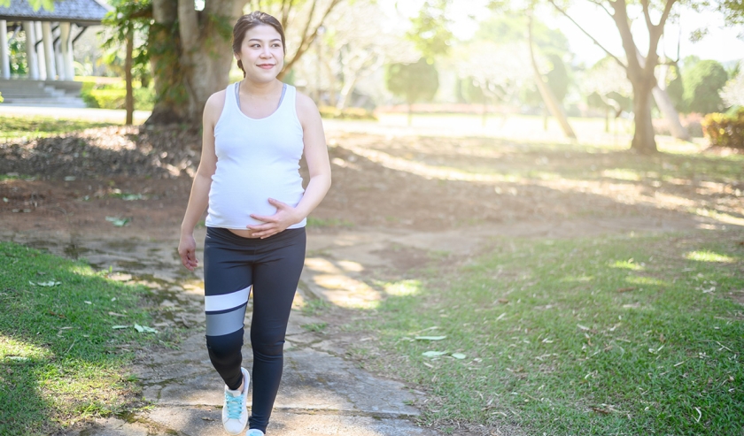 Portrait of young Asian pregnant woman walking and workout in the park