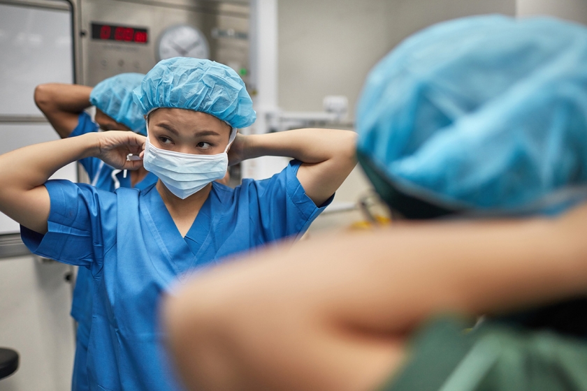 Medical professional putting on surgical scrubs