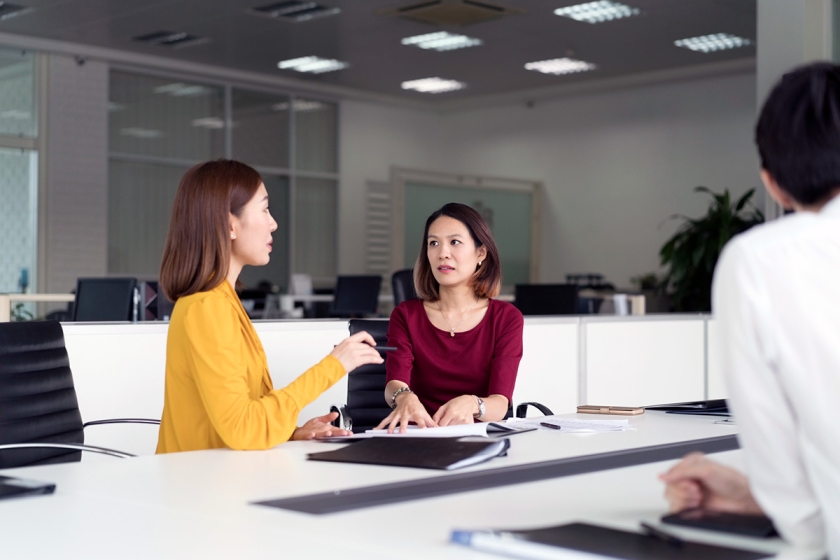 Two women discussing a project in an office.